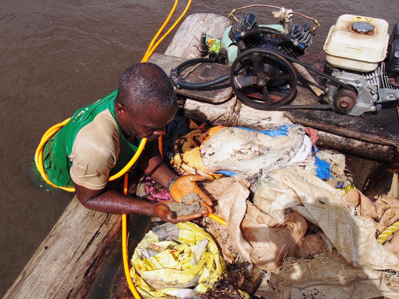 リベリアで川にもぐり、川底の土を掴んできた零細採掘労働者。川底の土にダイヤモンドが含まれていることがある。1日中、川にもぐって採掘を繰り返す。 (Photography: Chie Murakami, 2014, Smith Town, Liberia)