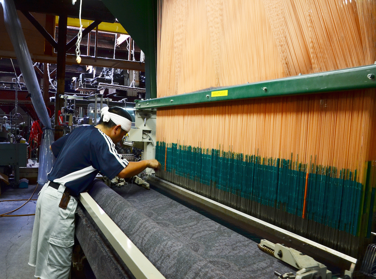 遠孫織布の遠藤さんは、夫婦だけで工場を切り盛り。遠藤さんは一人で11台の織機を操る。
