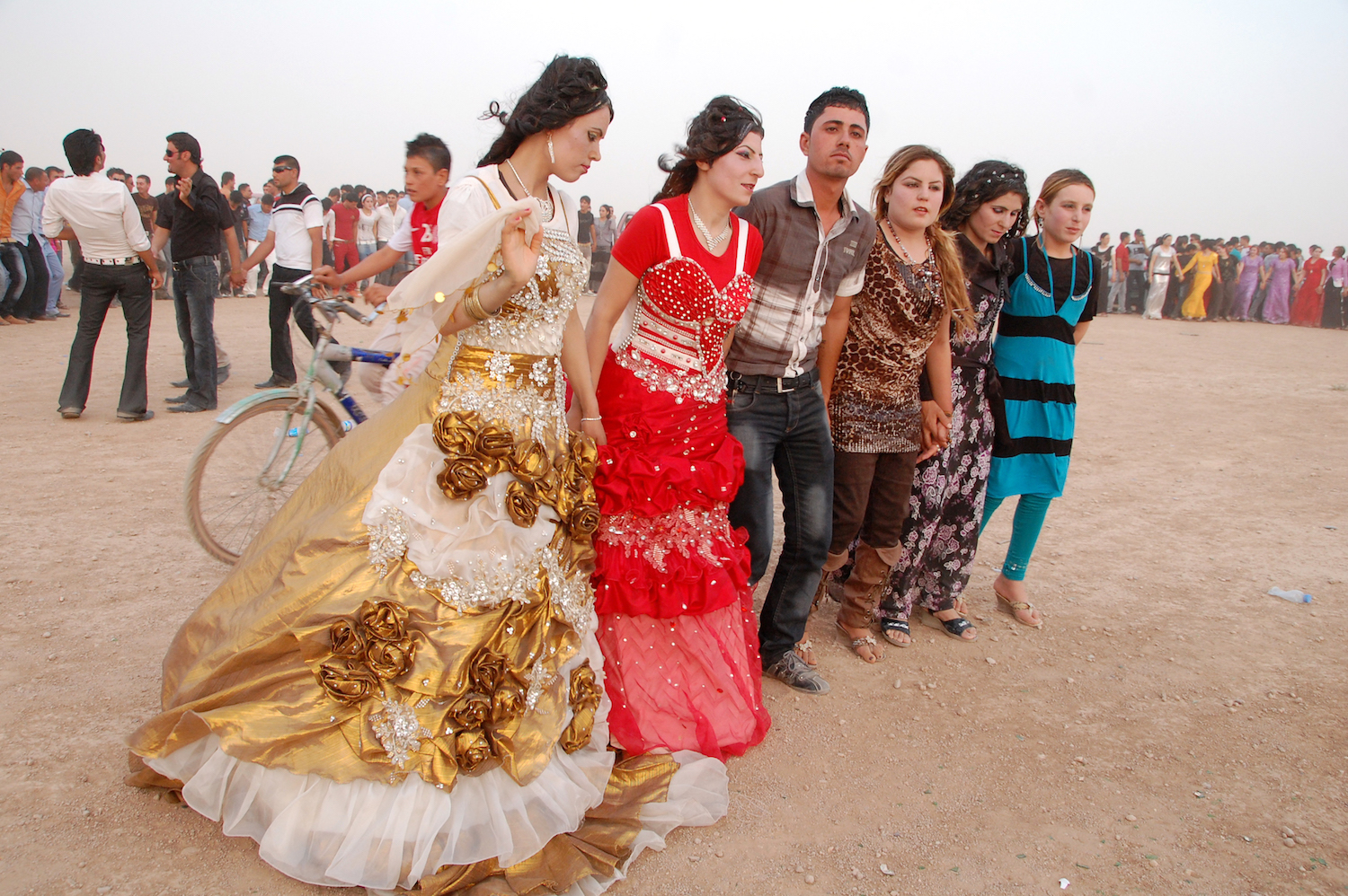 ヤズディー教徒の結婚式で、新郎新婦を祝福し、村の住民が数百人集まった。何もない砂漠で、男も女も手をつなぎ、歌に合わせて踊る。2年後、この村はISによって制圧された。（2012年7月 イラク北部 シンジャル郊外で撮影、Photography: Courtesy of 玉本英子）