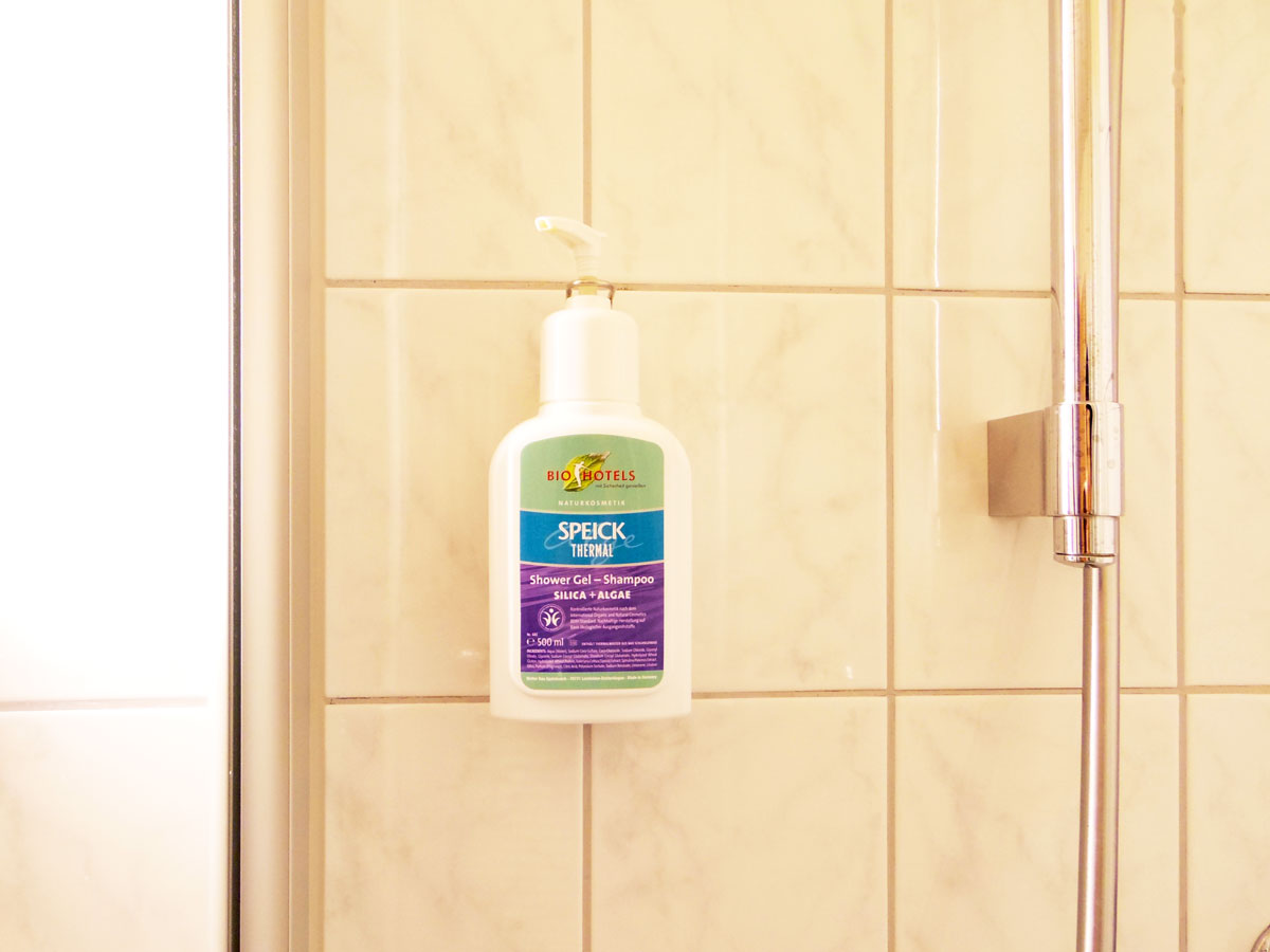 Eggensberger Biohotel Fussenのシャワールーム(2014年5月撮影)。壁に設置してあるBDIH(ドイツ化粧品医薬品商工業企業連盟)認証のナチュラルシャンプー&ボディジェル。(Photography: Mayuko Nakaishi)
