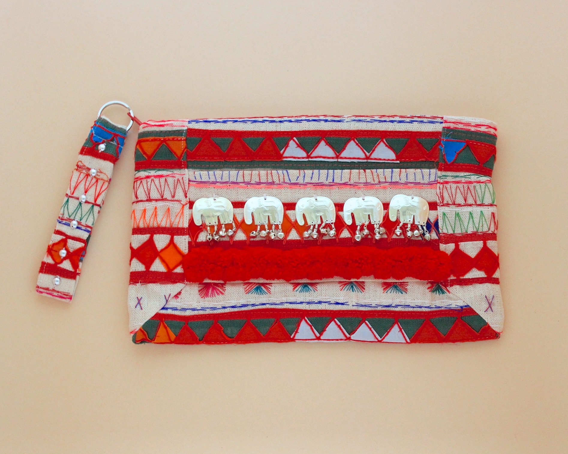アカ族の刺繍を施したテキスタイルに、ミェン族の赤いモコモコの装飾をあしたらったポーチ（提供：FUJI TATE P）